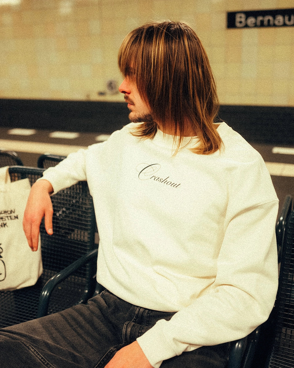 Cremeweißer Sweatshirt aus Baumwolle mit schwarzem, elegant geschwungenem Schriftzug „Crashout“ auf der Brust. Der Pullover hat einen Rundhalsausschnitt, lange Ärmel und breite Rippbündchen. Locker geschnitten und lässig getragen.