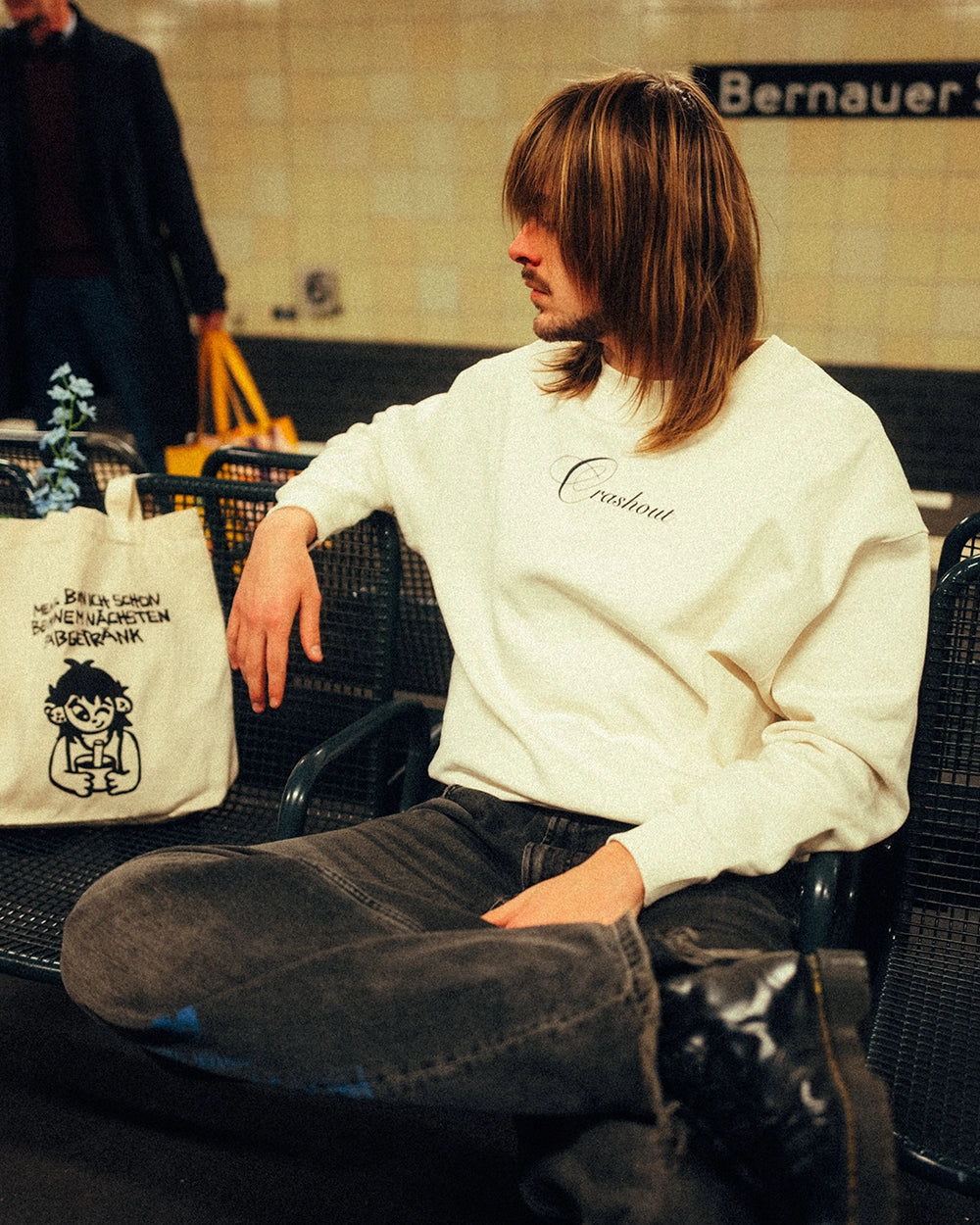 Cremeweißer Sweatshirt aus Baumwolle mit schwarzem, filigran geschwungenem Schriftzug „Crashout“ mittig auf der Brust. Der Pullover hat einen Rundhalsausschnitt, lange Ärmel und breite Rippbündchen. Locker geschnittenes Modell in klassischer, gerader Form.